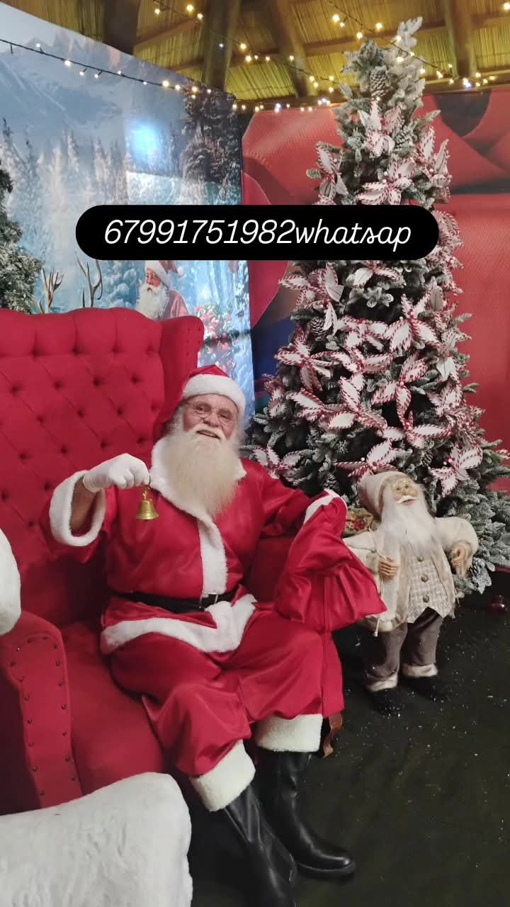 Papai Noel na poltrona vermelha junto à árvore de Natal